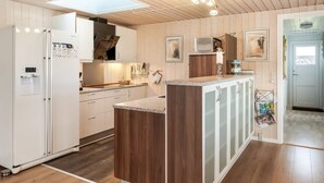 Una cucina moderna con mobili in legno, un'isola centrale e un forno a microonde integrato.