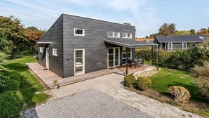 A modern two-story house with a dark exterior, large windows, and a covered patio area. - "Ilkka" - 175m from the sea by Interhome (Rødvig Stevns)