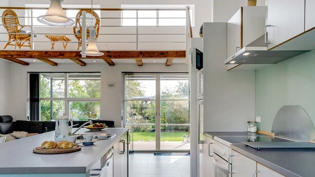 A modern kitchen with a large island, built-in appliances, and a view of the outdoors. - "Ilkka" - 175m from the sea by Interhome (Rødvig Stevns)