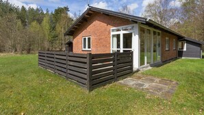 A single-story brick house with a wooden fence, a glass door, and a satellite dish. - "Eina" - 250m from the sea by Interhome (Hals)