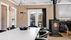 A modern kitchen with a dining table, chairs, a stove, and a view of the outdoors. - "Thorolf" - 30km from the sea by Interhome (Toftlund)