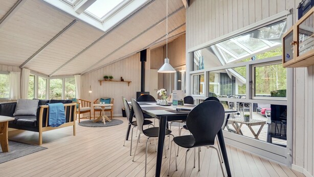 A spacious room with a high ceiling, skylights, a dining area with a table and chairs, and a cozy seating area with a sofa and chairs. - "Selver" - 250m from the sea by Interhome (Hals)