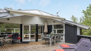 A modern outdoor deck with a dining area, lounge chairs, and a covered patio. - "Selver" - 250m from the sea by Interhome (Hals)