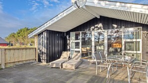 A covered outdoor patio with a table and chairs, a sliding glass door, and a satellite dish. - "Alaia" - 1km from the sea by Interhome (Vejers Strand)