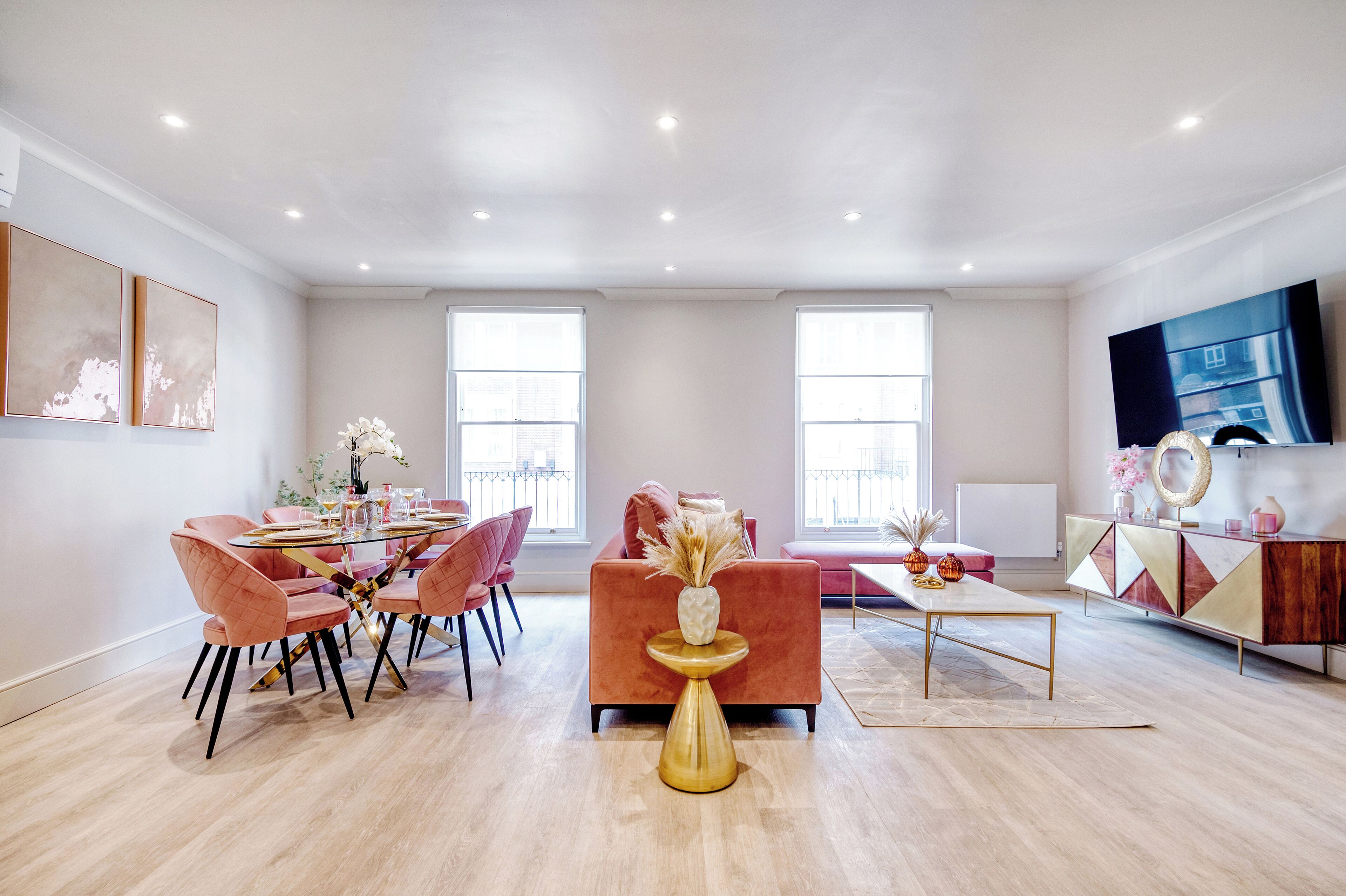 Un salon spacieux avec un coin repas, de grandes fenêtres et un meuble de rangement moderne pour les appareils multimédias.