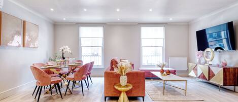 A spacious living room with a dining area, large windows, and a modern entertainment unit.