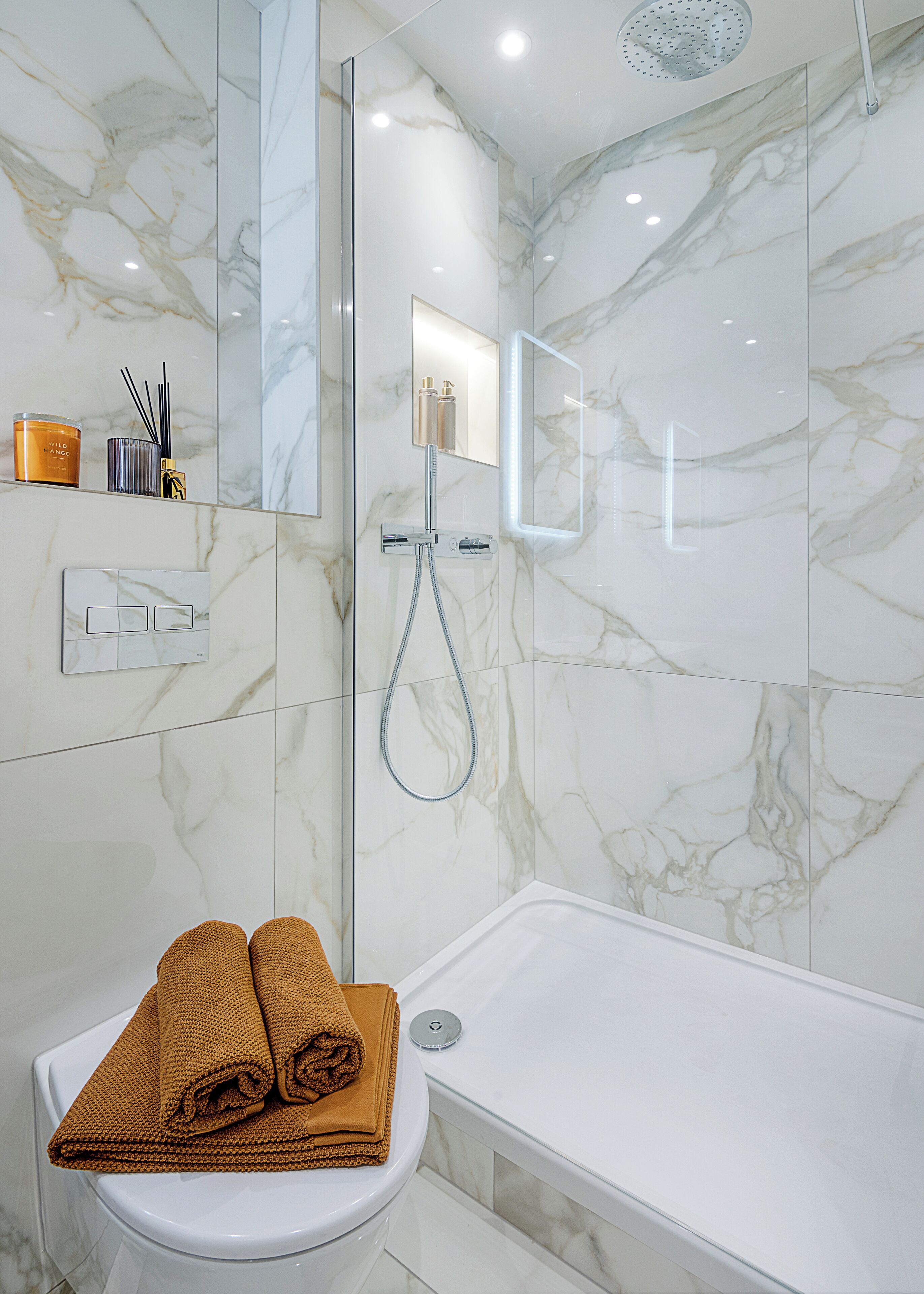 Un baño moderno con ducha de vidrio, inodoro blanco y bañera.