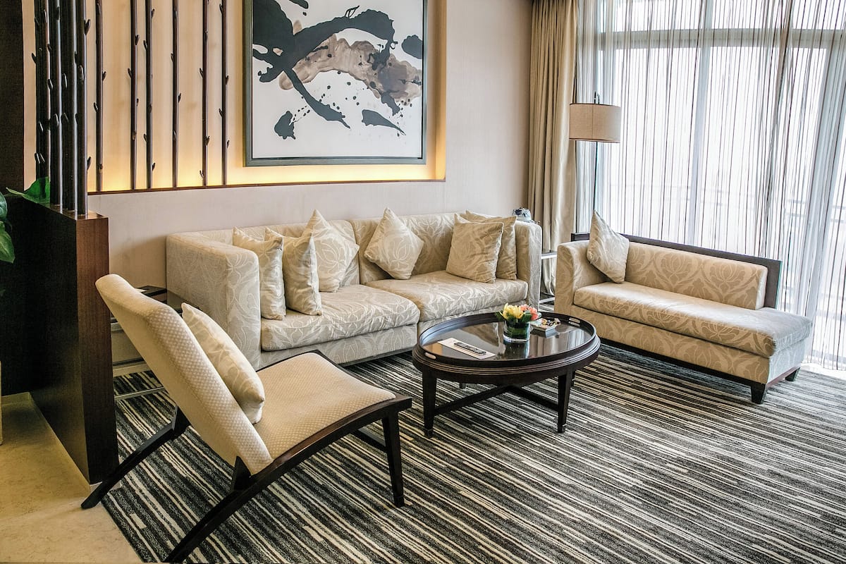 A modern living room with a sofa, armchair, and coffee table.