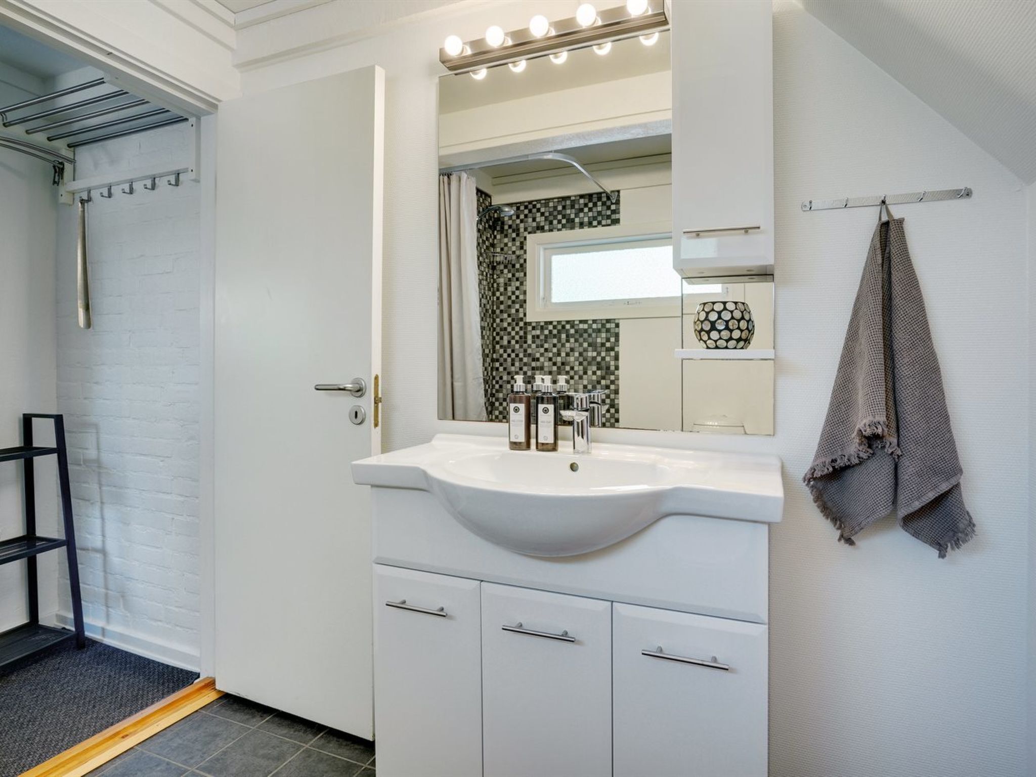 Ein modernes Badezimmer mit Waschbecken, Spiegel und Handtuchhalter.