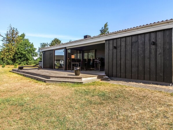 Un bâtiment moderne doté d’un patio couvert, de grandes fenêtres et d’un toit plat.