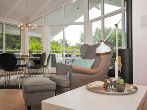Ein modernes Wohnzimmer mit hohen Decken, großen Fenstern und einer gemütlichen Sitzecke.