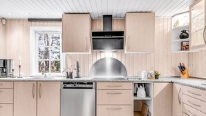 A modern kitchen with wooden cabinets, stainless steel appliances, and a window providing natural light. - "Daliborka" - 600m from the sea by Interhome (Hals)
