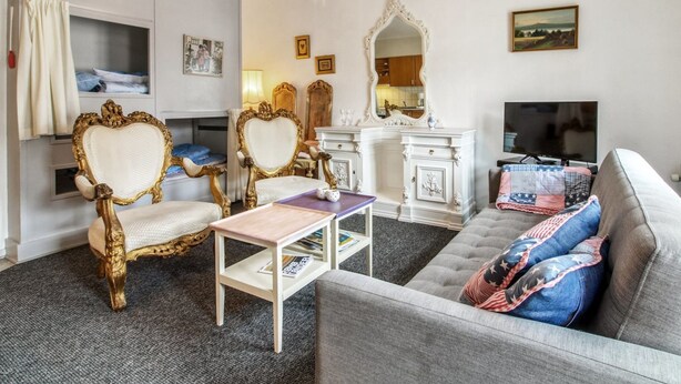 A living room with a grey sofa, two ornate chairs, a white cabinet, and a television. - "Ahvo" - 22km from the sea by Interhome (Bredebro)