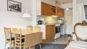 A compact kitchen with wooden cabinets, a dining table with chairs, a microwave, an oven, and a pendant light. - "Ahvo" - 22km from the sea by Interhome (Bredebro)