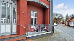 A red building with a white door and a small porch with a metal railing. - "Ahvo" - 22km from the sea by Interhome (Bredebro)