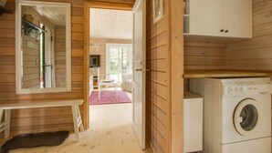 A wooden cabin interior with a laundry area, a dining area, and a view of the outdoors. - "Gaetana" - 1.6km from the sea by Interhome (Hals)