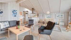 A spacious loft with a high ceiling, a dining area, and a kitchen.