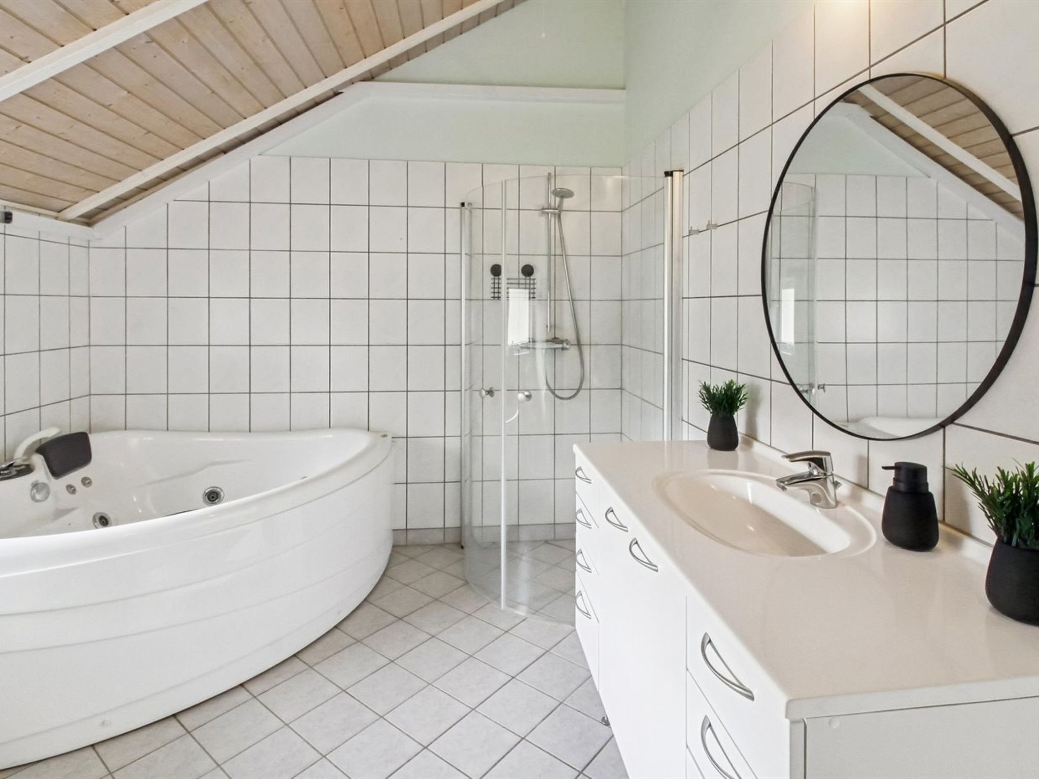 A modern bathroom with a freestanding bathtub, a walk-in shower, and a vanity with a mirror.