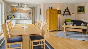 Un salon chaleureux avec une table à manger en bois, un canapé et un meuble.