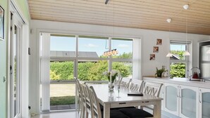 Una cocina moderna con comedor, ventanas amplias y vistas al exterior.