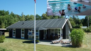 Una casa moderna con piscina, un porche cubierto e izado de bandera.