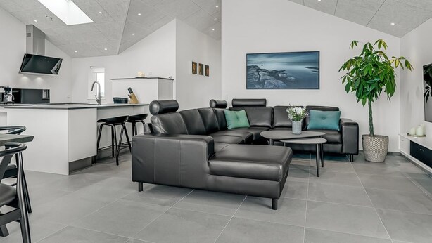 Una sala de estar moderna con un sofá modular, una mesa de centro y un televisor montado en la pared.