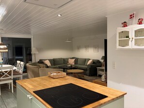 A modern kitchen with a central island, a dining area with a table and chairs, and a living area with a sofa and a coffee table. - "Aud" - 300m from the sea by Interhome (Hals)