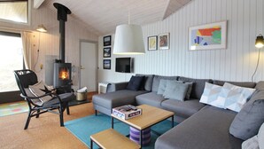 A cozy living room with a fireplace, a sofa, a coffee table, and a TV.
