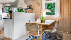 A cozy kitchen with a central island, wooden walls, and a window with a view of greenery. - "Myrna" - 300m from the sea by Interhome (Hals)