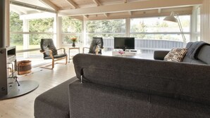 A modern living room with a large gray sofa, two leather chairs, a TV, and a fireplace. - "Siegrid" - 250m from the sea by Interhome (Hals)