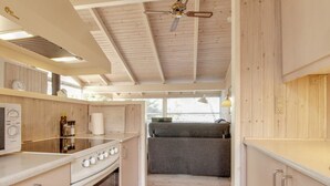 A compact kitchen with a stove, oven, and a small dining area with a bench. - "Siegrid" - 250m from the sea by Interhome (Hals)