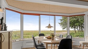 A dining area with a large table, chairs, and a view of the outdoors.
