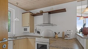 A kitchen with a built-in oven, microwave, and a stainless steel range hood.