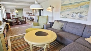 A cozy living room with a sofa, a round table, and a painting of seagulls on the wall. - "Clausina" - 600m from the sea by Interhome (Bredebro)