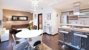 A modern kitchen with a central island, bar stools, and a built-in oven. - Magnifique 2 Pièces Parc Monceau Paris 8 (Paris)
