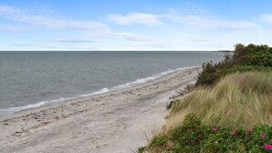 Uma praia com céu claro e mar calmo.