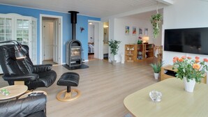 En moderne stue med pejs, læder møbler, et fladskærms TV og et spisebord.