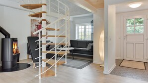 Een modern interieur met een spiltrap, een open haard en een gezellige zithoek.