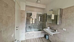 A modern bathroom with a large mirror, a bathtub, and a sink. - *4 double bedrooms *fully equipped kitchen *2 living rooms with smart TVs *air conditioning (L'Aquila)