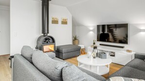 A modern living room with a fireplace, grey sofas, a coffee table, and a flat-screen TV. - "Hejdie" - 150m from the sea by Interhome (Hals)