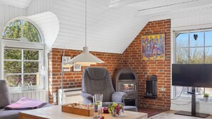 Una sala de estar acogedora con chimenea, televisor y un ventanal amplio.