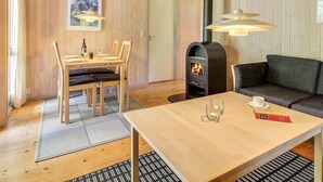 A cozy room with a wooden interior, a dining table with chairs, a sofa, a fireplace, and a painting on the wall. - "Frederikke" - 28km from the sea by Interhome (Toftlund)