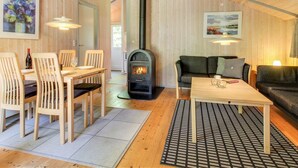 A cozy living room with a wooden interior, a fireplace, a dining area, and a sofa. - "Frederikke" - 28km from the sea by Interhome (Toftlund)