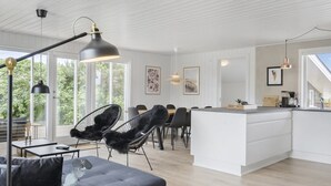 A modern kitchen with white cabinetry, a central island, and pendant lighting.