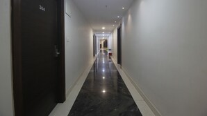 A hallway with a dark door labeled '304', white walls, and a shiny black floor.