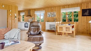 A cozy wooden cabin interior with a dining area, kitchen, and seating space. - "Rikhard" - 75m from the sea by Interhome (Dannemare)