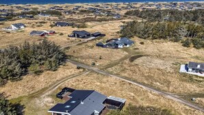 An aerial view of a residential area with houses, a large wooden deck, and a view of the ocean. - "Nienke" - 700m from the sea by Interhome (Løkken)