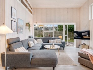 A modern living room with a grey sectional sofa, a round coffee table, and a flat-screen TV mounted on the wall. - "Ylvi" - 250m from the sea by Interhome (Ebeltoft)