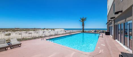 A rooftop pool with a clear view of the beach and ocean.