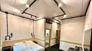 A compact hotel room with a single bed, a small desk with a chair, a sofa, and a mirror. - ART HOTEL 158 (Sofia)